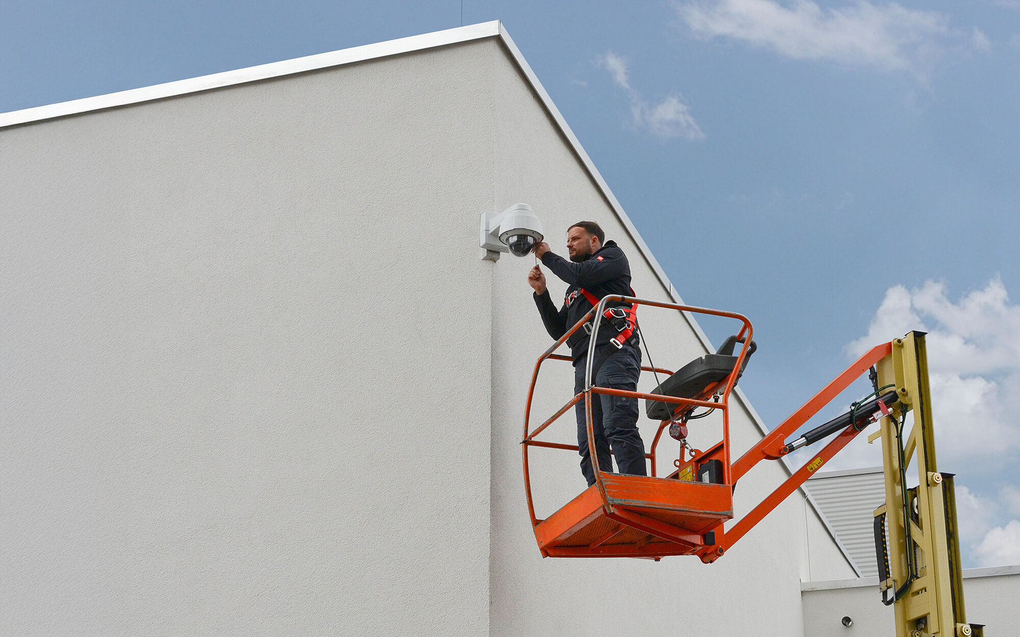 Techniker installiert Kamera mit Hebebühne