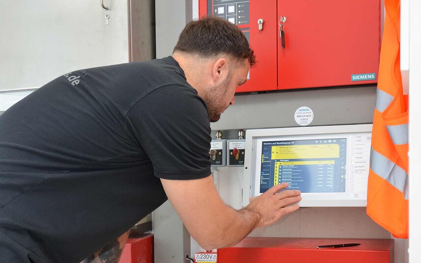 Techniker bedient digitale Siemens-Brandmeldeanlage