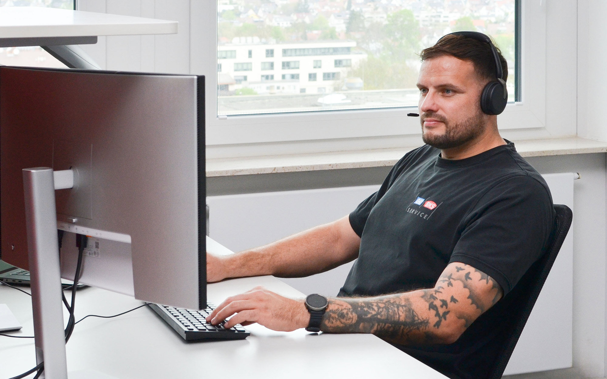 Mann mit Headset arbeitet am Computer