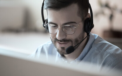 Supportmitarbeiter mit Headset am Computer