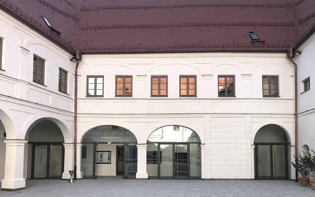 Innenhof mit Arkaden und roten Dachziegeln